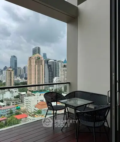 Stunning city view from a modern balcony with outdoor seating, perfect for relaxation and entertainment.