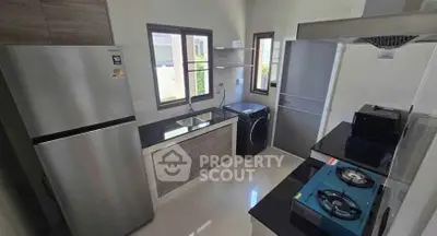 Modern kitchen with sleek appliances and gas stove in a compact layout.