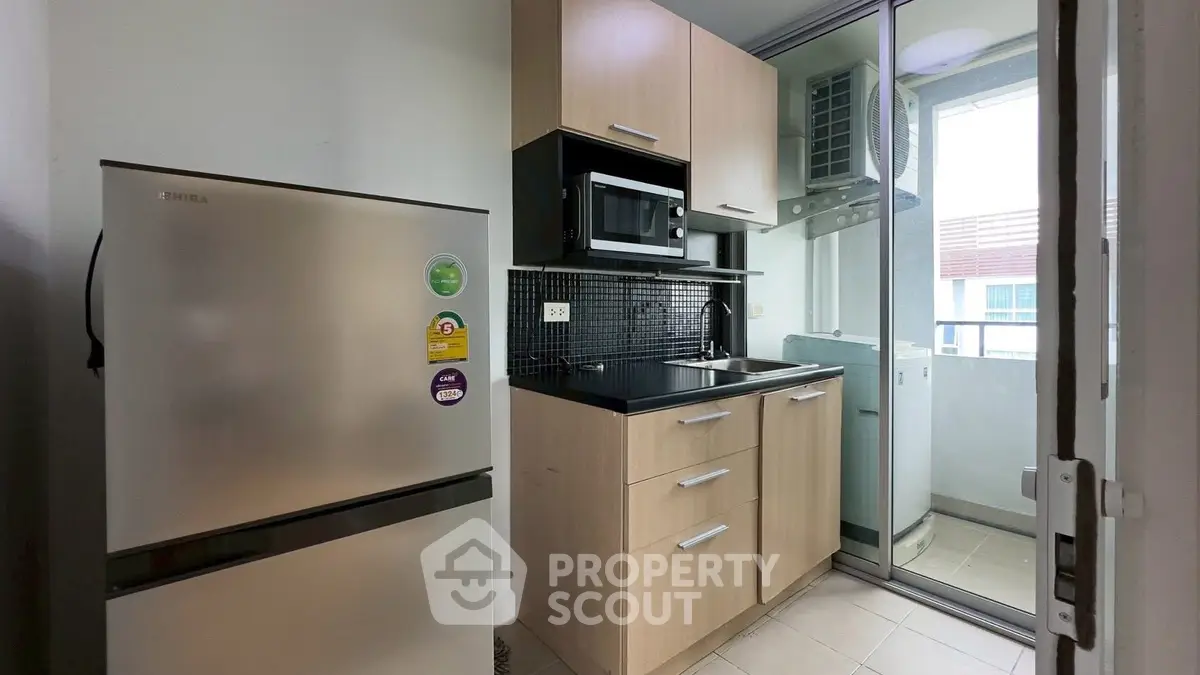 Modern kitchen with sleek appliances and balcony view