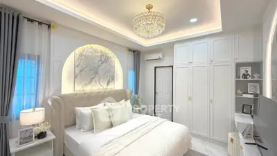 Luxurious bedroom with elegant chandelier and built-in wardrobes, featuring a plush bed and modern decor.