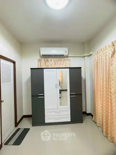 Spacious bedroom with modern wardrobe and air conditioning unit, perfect for comfortable living.