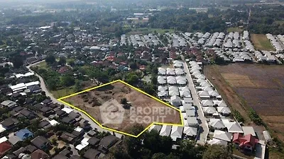 Aerial view of residential development site with outlined plot in suburban area.