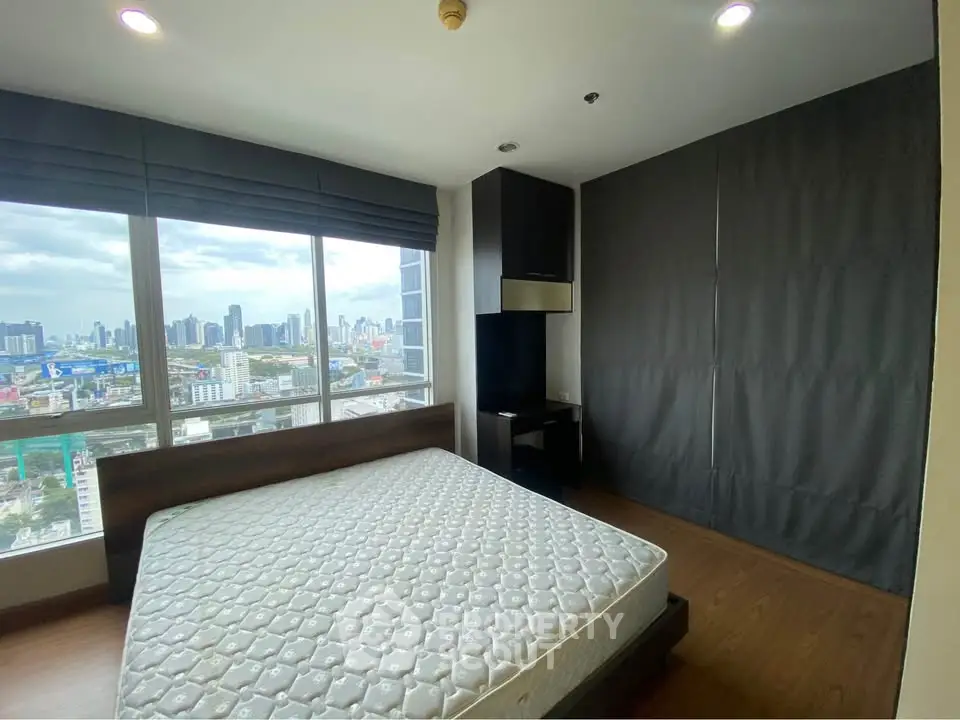 Modern bedroom with city view and large windows in high-rise apartment