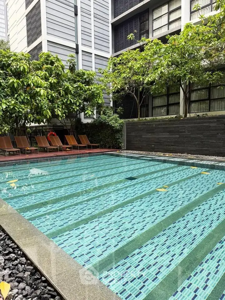 Luxurious residential pool area with lush greenery and modern design, perfect for relaxation and leisure.