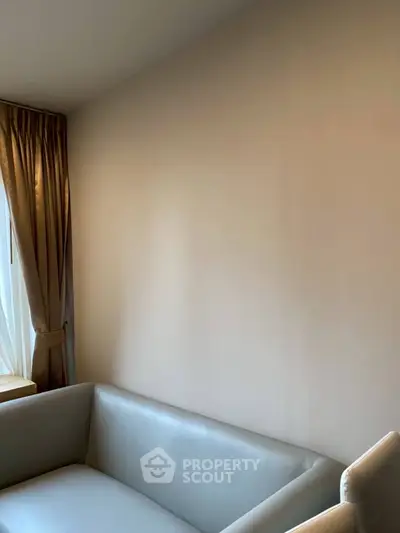 Cozy living room corner with elegant sofa and floor-to-ceiling curtains