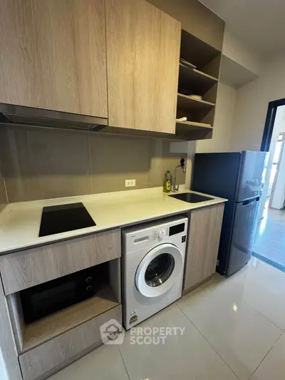 Modern kitchen with washing machine and sleek appliances in stylish apartment