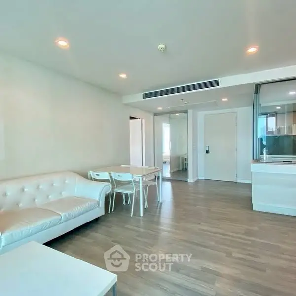 Spacious modern living room with elegant white furniture and wooden flooring