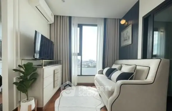 Modern living room with stylish sofa, large window, and sleek decor in a high-rise apartment.