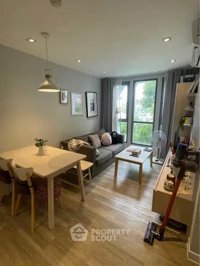 Charming modern living room with cozy dining area and large windows.