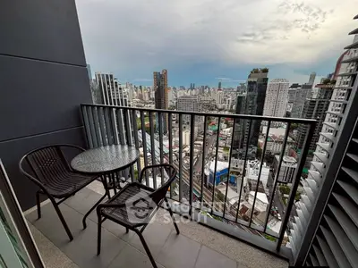 Stunning cityscape view from a modern high-rise balcony with seating area.