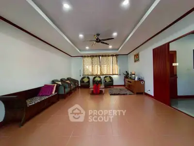 Spacious living room with elegant ceiling fan and ample seating.