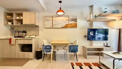 Modern open-layout living room with stylish kitchen and dining area, featuring contemporary decor and ample natural light.