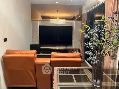 Modern living room with leather seating and large TV, perfect for entertainment.