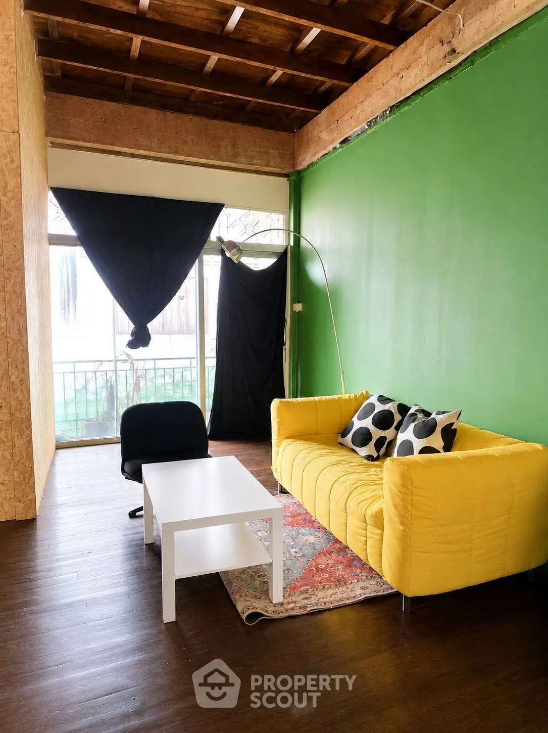 Charming living room with vibrant yellow sofa and rustic wooden ceiling, perfect for cozy gatherings.