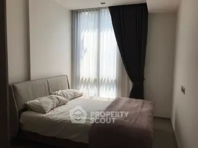 Cozy bedroom with natural light and elegant curtains in modern apartment.