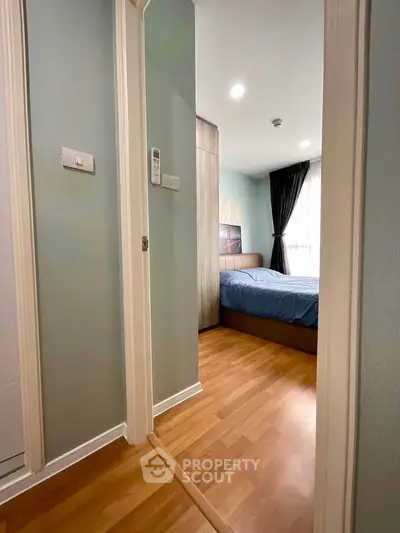 Cozy bedroom with wooden flooring and modern decor in a stylish apartment.