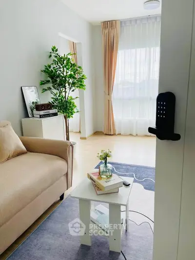 Charming living room with cozy sofa, elegant decor, and natural light through large window.