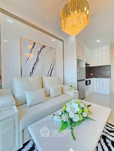 Luxurious living room with elegant chandelier and modern kitchen in open layout apartment.