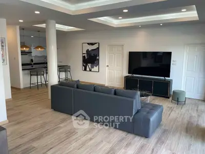 Spacious modern living room with sleek furniture and open kitchen layout