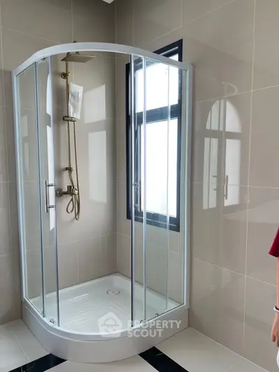 Modern bathroom with sleek glass shower enclosure and elegant fixtures.