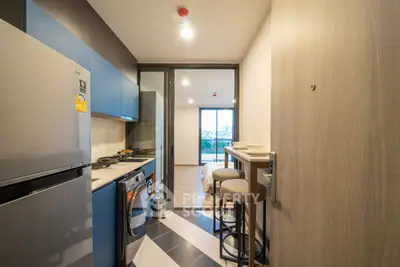 Modern kitchen with sleek appliances and open layout leading to a bright living area with city view.