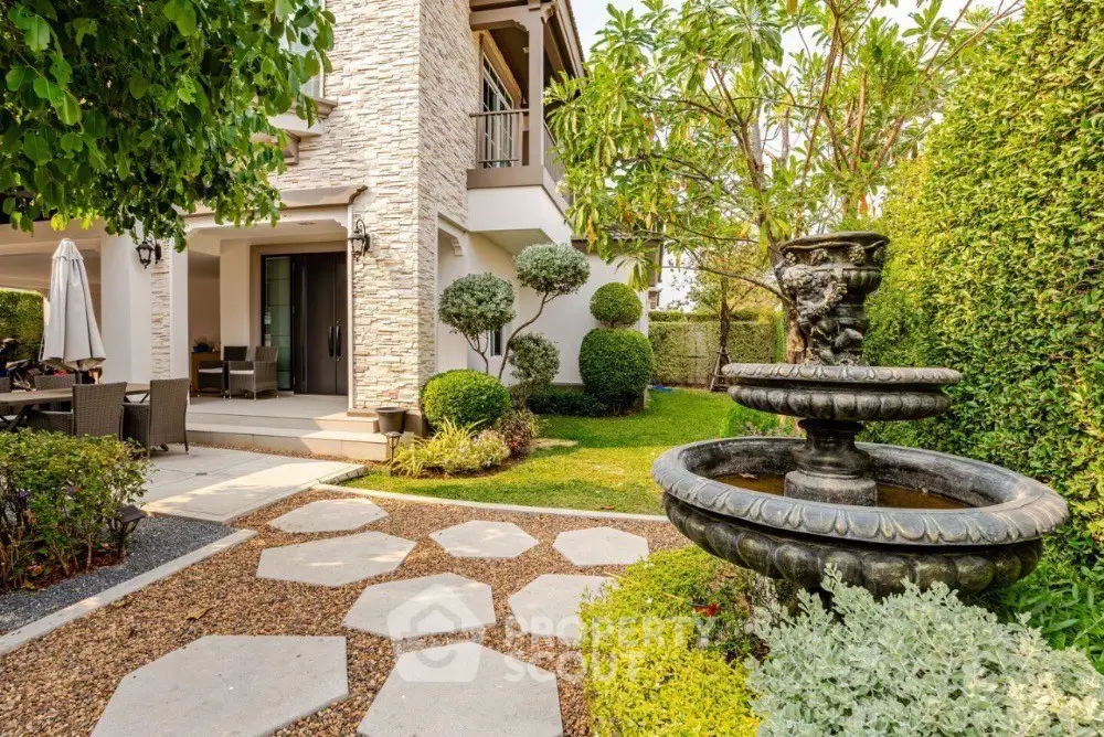 Luxurious garden with elegant stone pathway and classic fountain in upscale residential property.