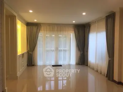 Spacious living room with elegant curtains and polished floors
