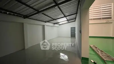 Spacious industrial-style storage unit with metal roofing and polished concrete floor.