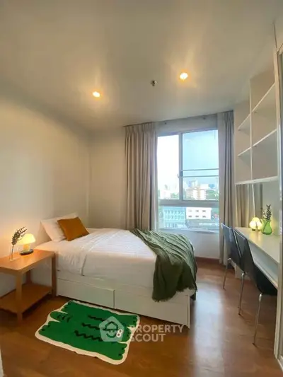 Cozy bedroom with modern decor, featuring a single bed, study desk, and large window with city view.