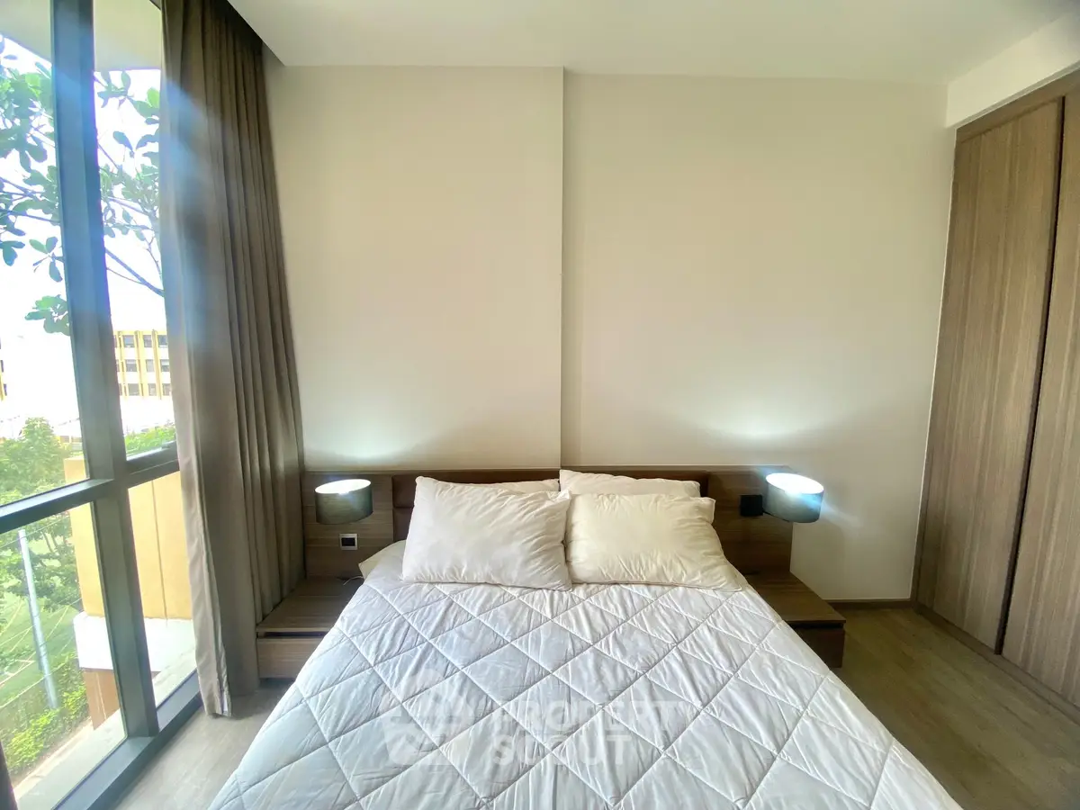 Modern bedroom with large window and cozy bed in stylish apartment.