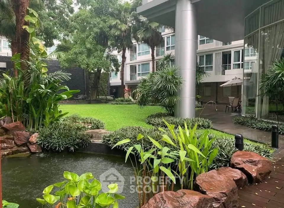 Luxurious garden view in modern residential complex with lush greenery and serene pond.