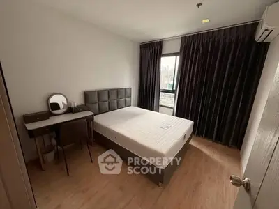 Cozy bedroom with modern furniture and large window for natural light.