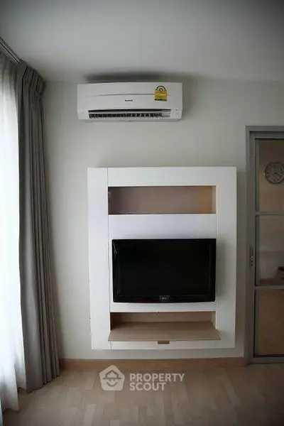 Modern living room with wall-mounted TV and air conditioning unit