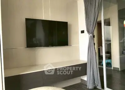 Modern living room with wall-mounted TV and stylish decor in a contemporary apartment.