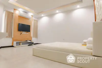 Spacious modern bedroom with minimalist design and wall-mounted TV