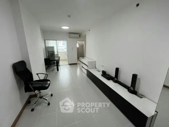 Modern minimalist living room with sleek furniture and office setup, ideal for urban living.