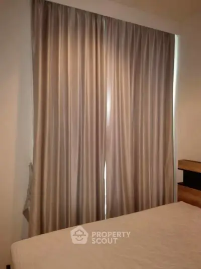Cozy bedroom with elegant curtains and modern wooden furniture, perfect for relaxation.
