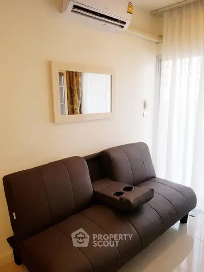 Modern living room with sleek brown sofa and wall-mounted air conditioner.
