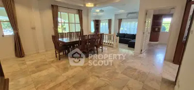Spacious open-plan living and dining area with elegant marble flooring and large windows.