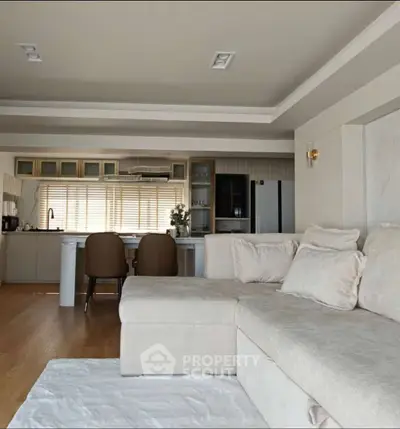 Spacious modern living room with cozy sectional sofa and open kitchen layout.