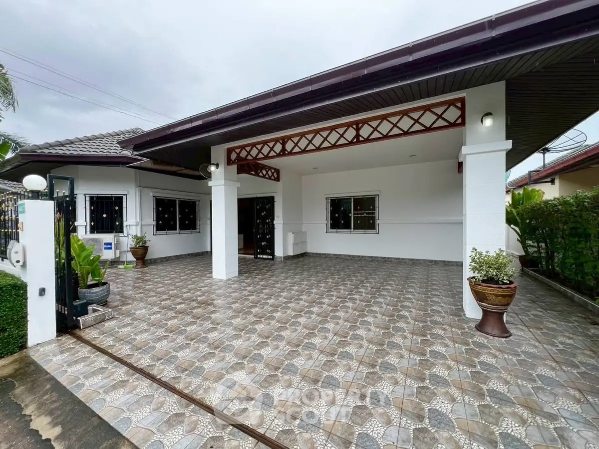 Charming single-story home with spacious tiled driveway and modern exterior design.