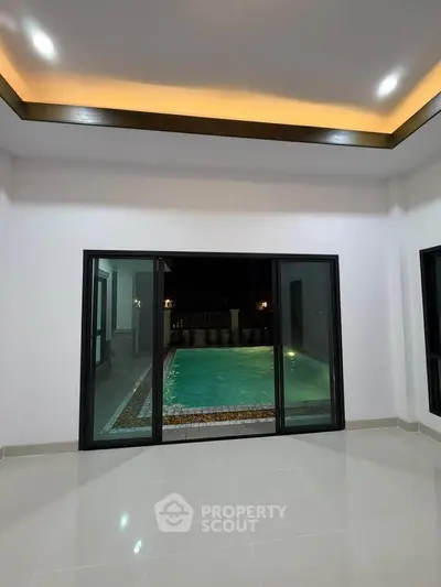 Luxurious interior with pool view through large sliding glass doors, perfect for modern living.