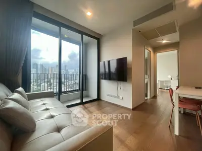 Modern living room with city view, featuring sleek furniture and large windows for natural light.