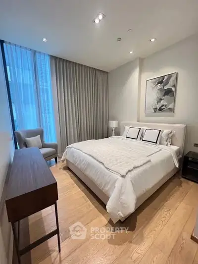 Modern bedroom with elegant decor and large window in luxury apartment.