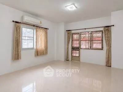 Spacious unfurnished room with large windows and air conditioning, perfect for customization.