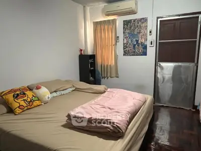 Cozy bedroom with air conditioning and wooden flooring, featuring a comfortable bed and stylish decor.