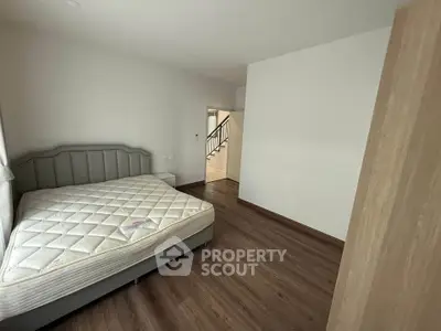 Spacious bedroom with modern design and wooden flooring in a contemporary home.