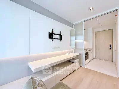 Modern minimalist living room with sleek built-in furniture and open kitchen layout.