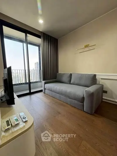Modern living room with sleek sofa and balcony view in high-rise apartment