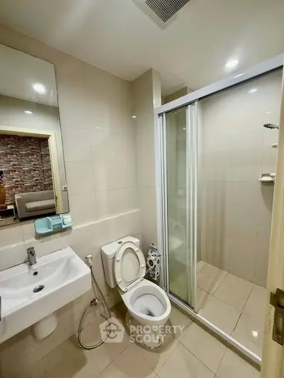 Modern bathroom with glass shower and sleek fixtures in contemporary apartment.